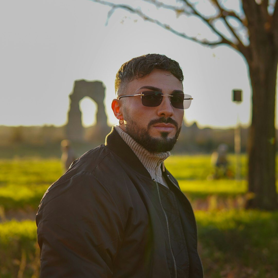 Studio portrait of a young man with glasses smiling